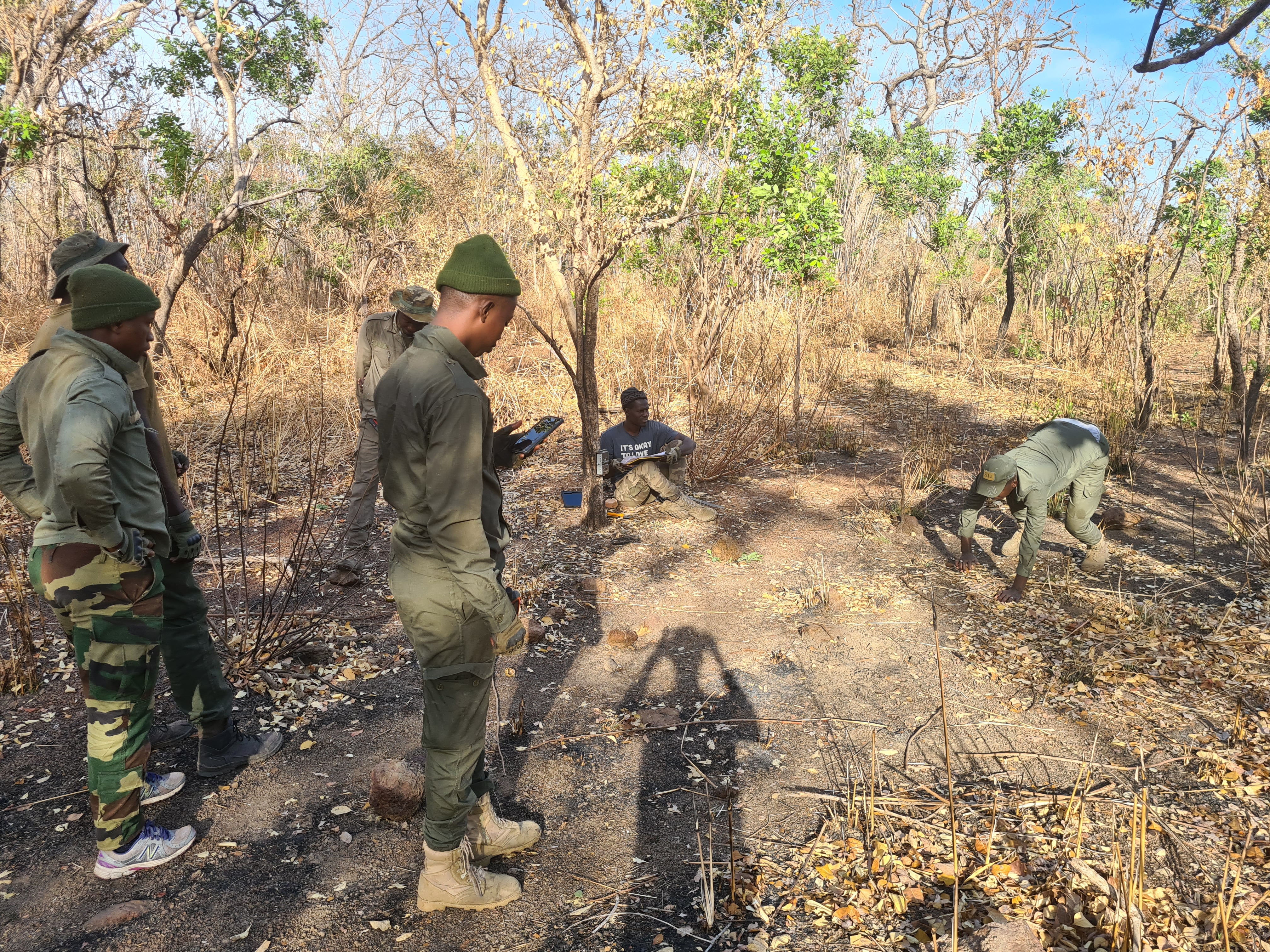 Team leaders carrying out a practical exercise on camera deployment, with a team member crawling in front of the camera to check picture framing. 