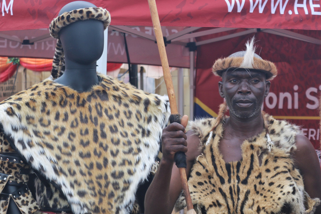 A Ncwala participant stands next to Panthera's Heritage Furs