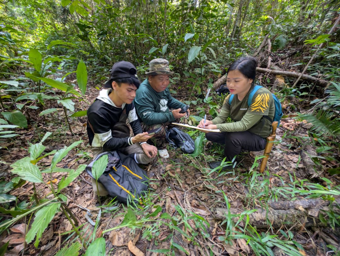 Beathres records field data alongside local community members in Sabah.